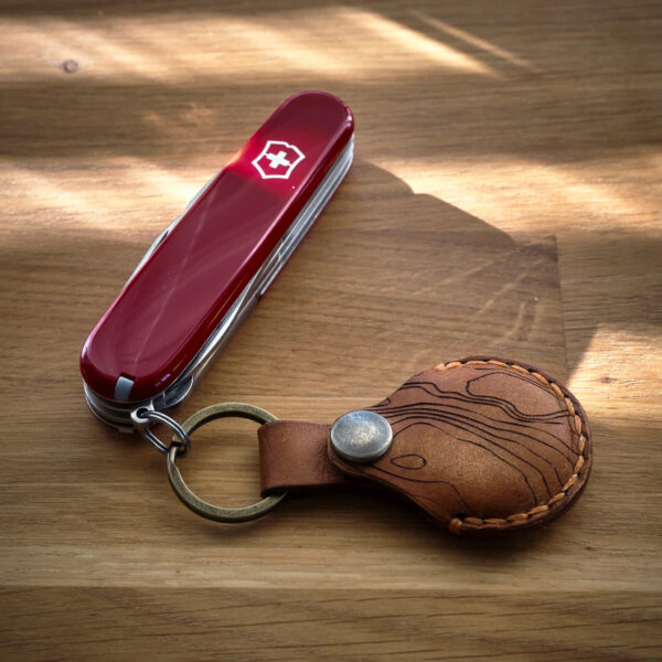 Victorinox Super Tinker med en handsydd brun Apple AirTag nyckelring i läder med topografiskt mönster som är tillverkad i Sverige.