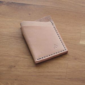 Minimalistisk handsydd plånbok Old Tjikko i vegetabiliskt garvat naturfärgat läder och färgmatchad tråd. Tre fickor med plats för kort. Tillverkad i Sverige.