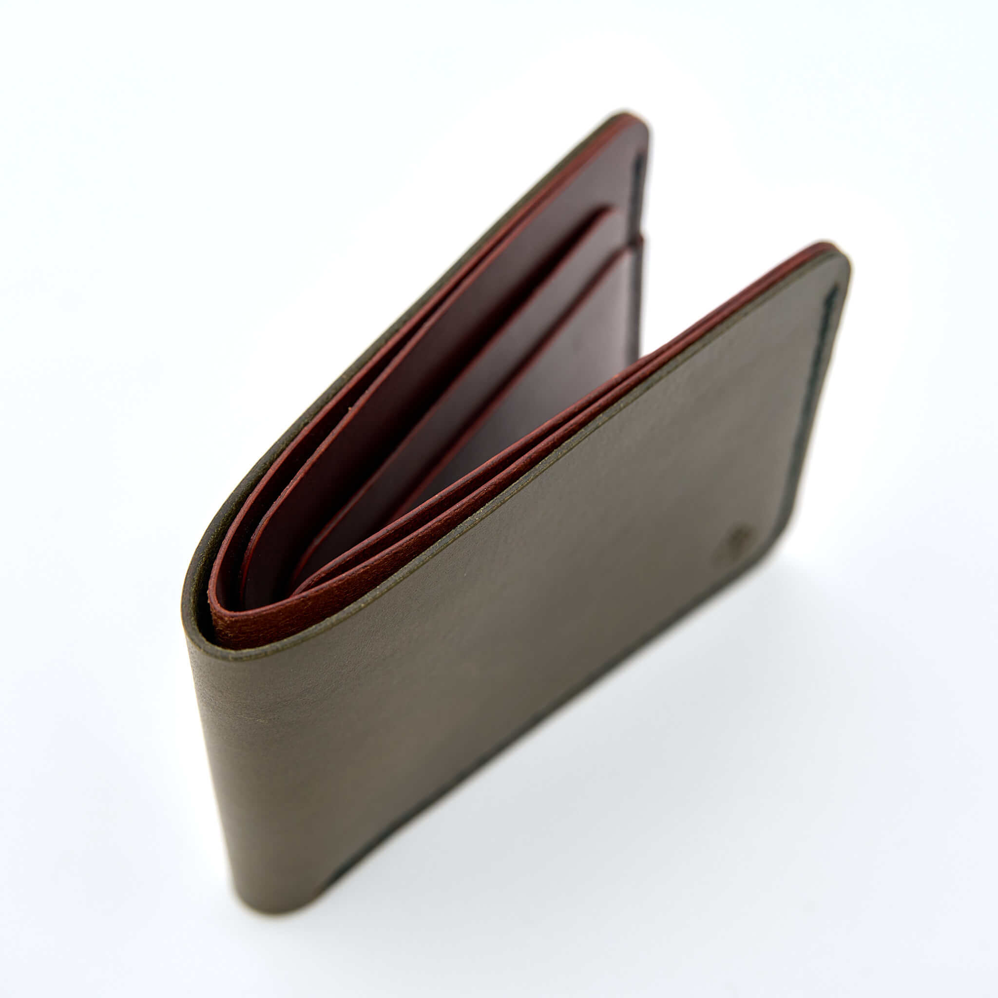 Handsydd bi-fold plånbok i vegetabiliskt garvat läder. Det olivfärgade lädret kommer från Italienska Conceria Walpier och det cognacfärgat lädret kommer från Tärnsjö Garveri. Tillverkad i Sverige av K Creative Craft.
