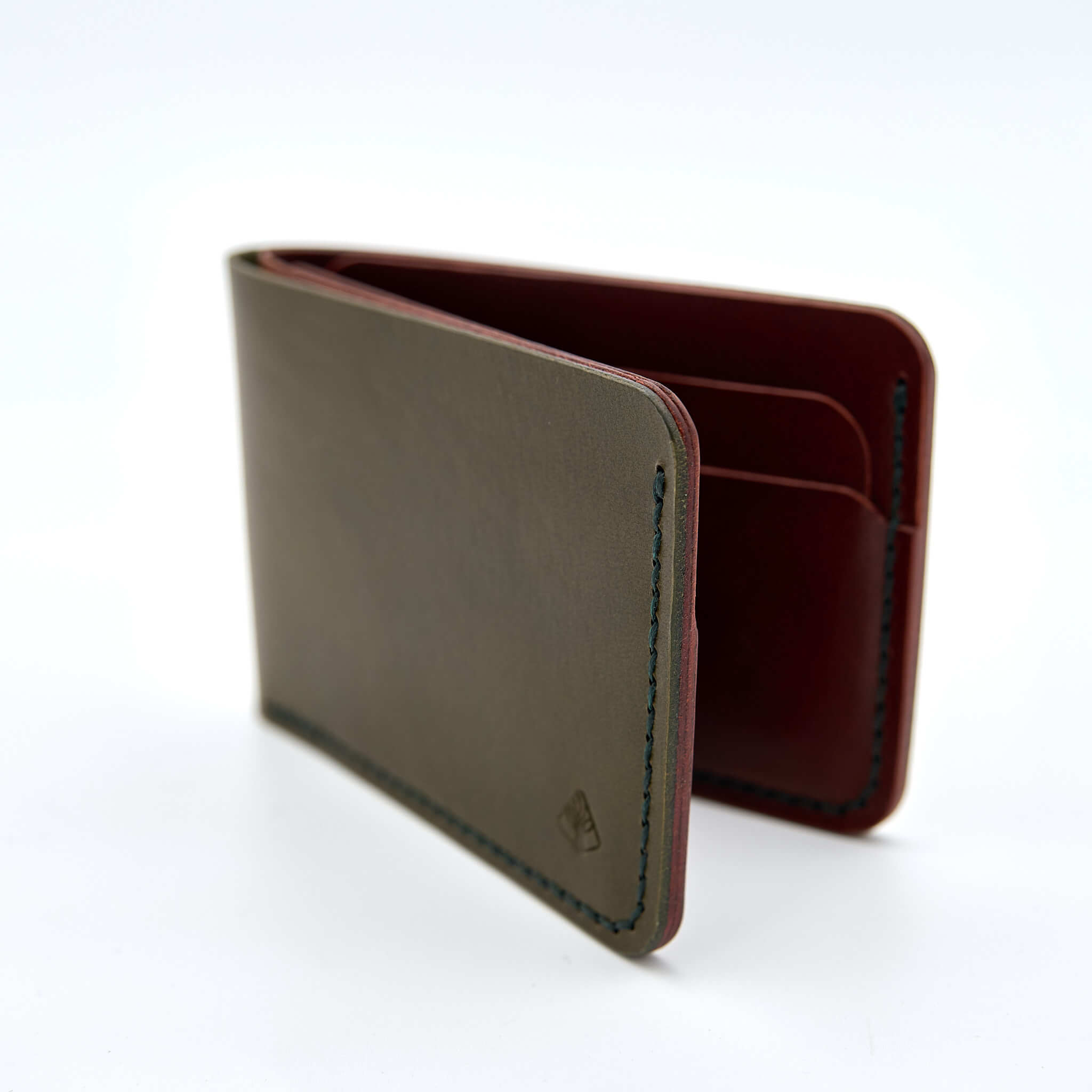 Handsydd bi-fold plånbok i vegetabiliskt garvat läder. Det olivfärgade lädret kommer från Italienska Conceria Walpier och det cognacfärgat lädret kommer från Tärnsjö Garveri. Tillverkad i Sverige av K Creative Craft.