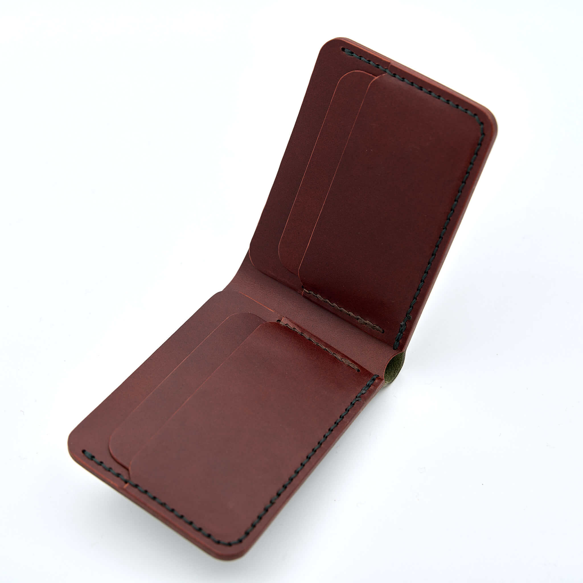 Handsydd bi-fold plånbok i vegetabiliskt garvat läder. Det olivfärgade lädret kommer från Italienska Conceria Walpier och det cognacfärgat lädret kommer från Tärnsjö Garveri. Tillverkad i Sverige av K Creative Craft.