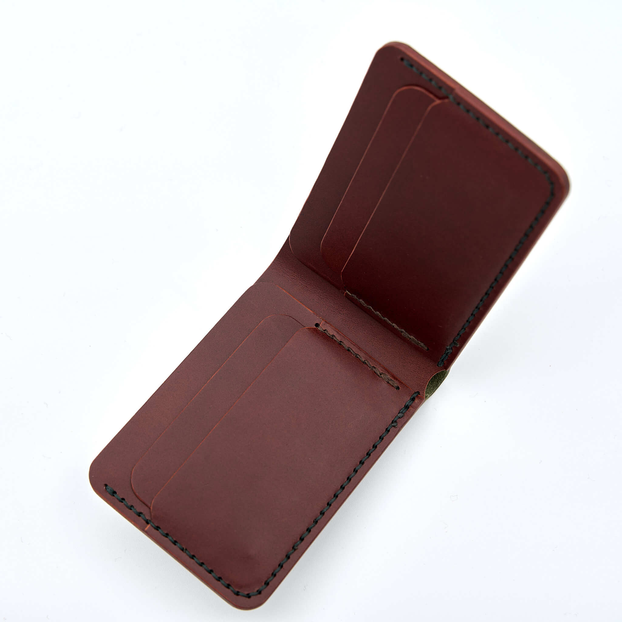 Handsydd bi-fold plånbok i vegetabiliskt garvat läder. Det olivfärgade lädret kommer från Italienska Conceria Walpier och det cognacfärgat lädret kommer från Tärnsjö Garveri. Tillverkad i Sverige av K Creative Craft.