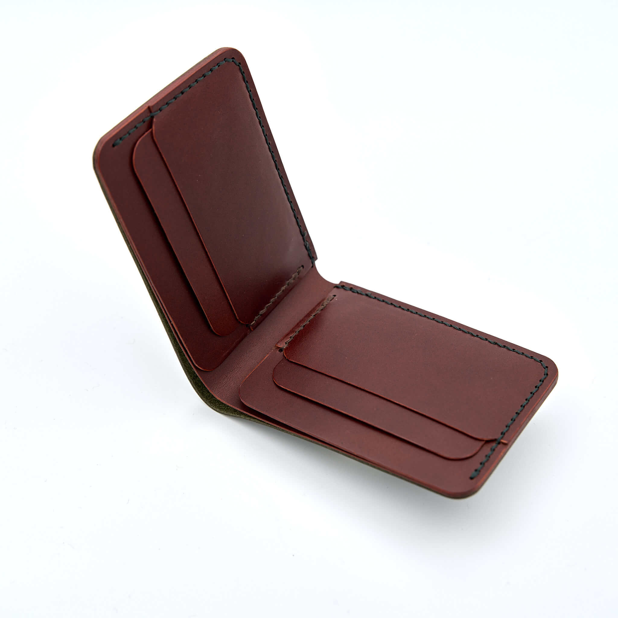 Handsydd bi-fold plånbok i vegetabiliskt garvat läder. Det olivfärgade lädret kommer från Italienska Conceria Walpier och det cognacfärgat lädret kommer från Tärnsjö Garveri. Tillverkad i Sverige av K Creative Craft.