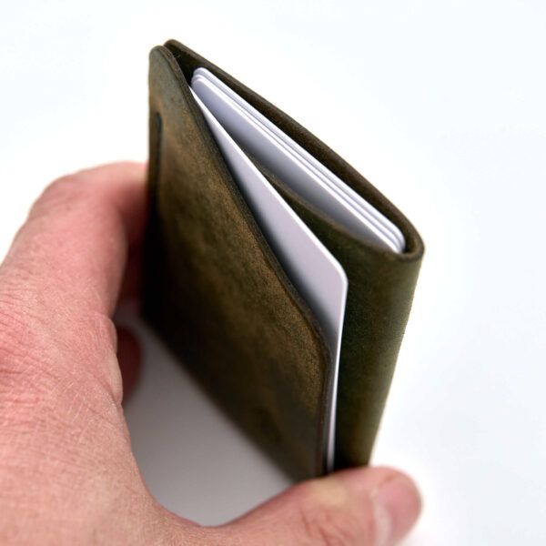 Minimalistisk handsydd plånbok Hamptjärn i vegetabiliskt garvat grönt läder och färgmatchad tråd. Två fickor med plats för kort och sedlar. Tillverkad i Sverige.