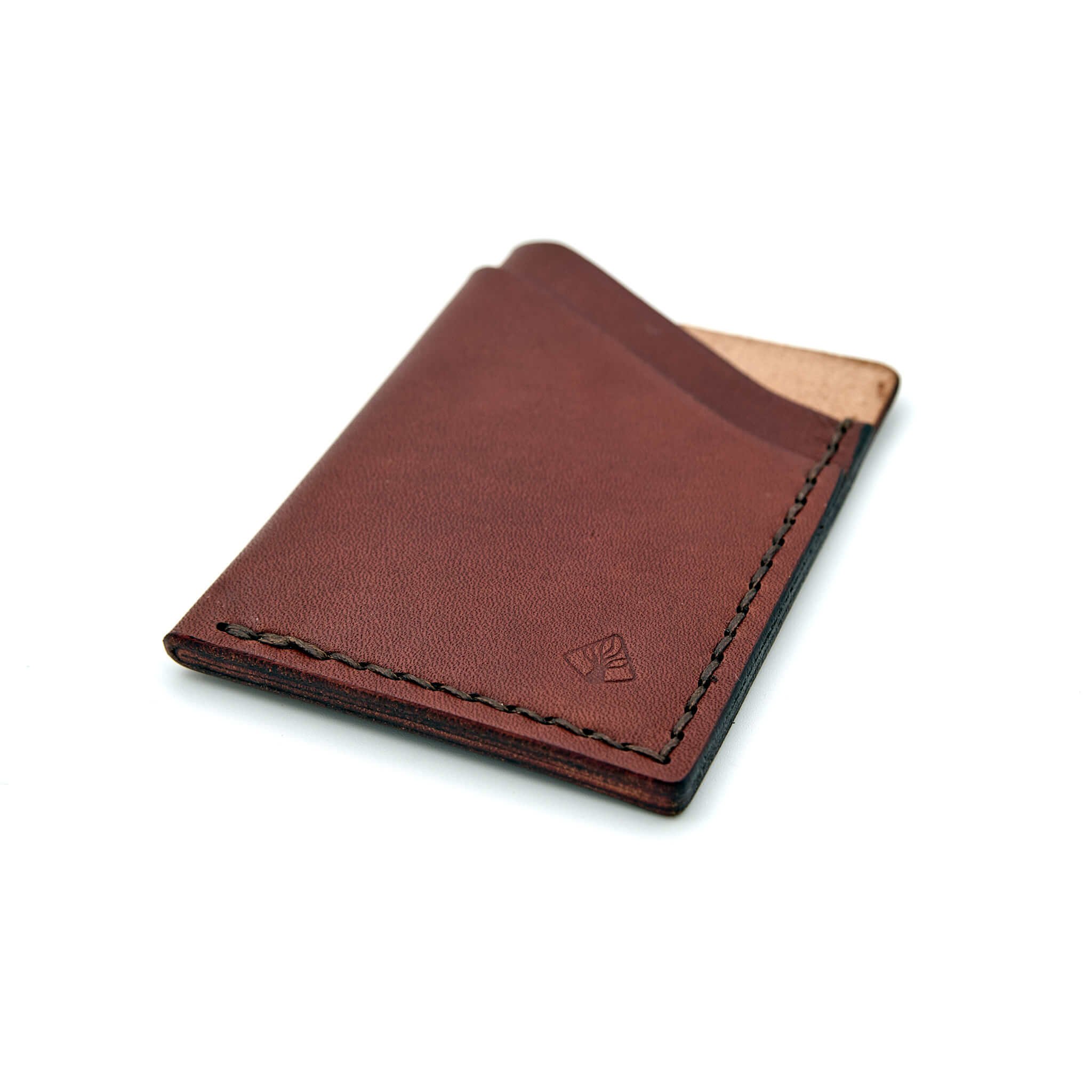 Minimalistisk handsydd plånbok Old Tjikko i vegetabiliskt garvat brunt läder och färgmatchad tråd. Tre fickor med plats för kort och sedlar. Tillverkad i Sverige.