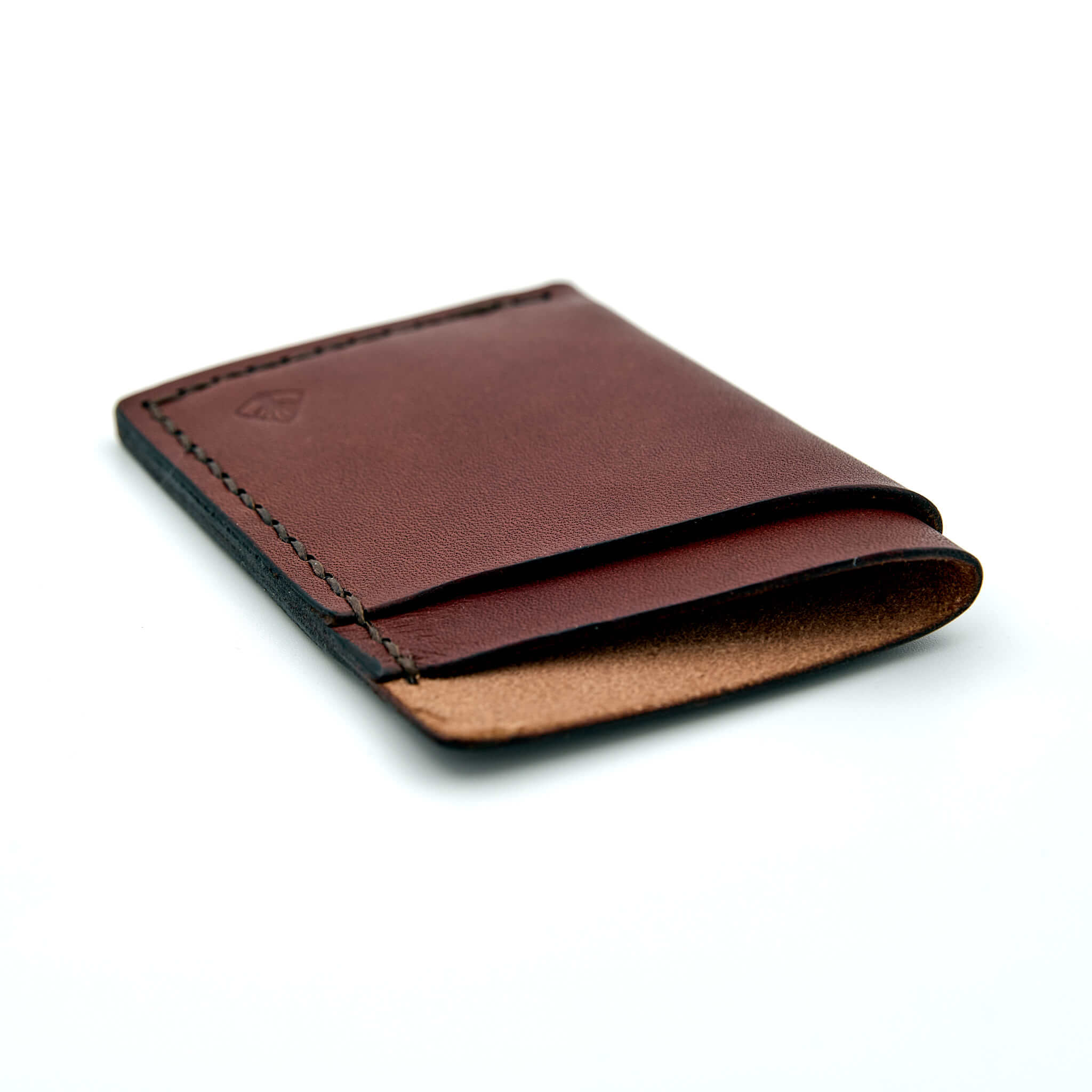 Minimalistisk handsydd plånbok Old Tjikko i vegetabiliskt garvat brunt läder och färgmatchad tråd. Tre fickor med plats för kort och sedlar. Tillverkad i Sverige.