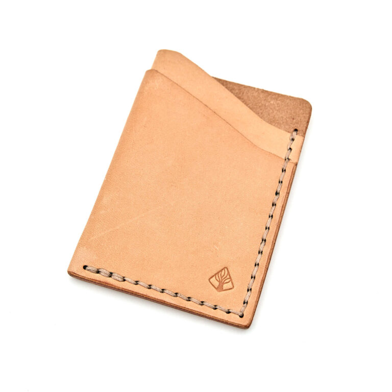 Minimalistisk handsydd plånbok Old Tjikko i vegetabiliskt garvat naturfärgat läder och färgmatchad tråd. Tre fickor med plats för kort och sedlar. Tillverkad i Sverige.