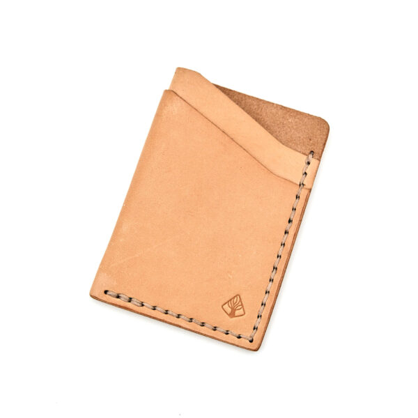 Minimalistisk handsydd plånbok Old Tjikko i vegetabiliskt garvat naturfärgat läder och färgmatchad tråd. Tre fickor med plats för kort och sedlar. Tillverkad i Sverige.