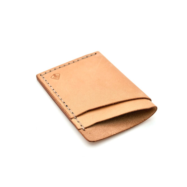 Minimalistisk handsydd plånbok Old Tjikko i vegetabiliskt garvat naturfärgat läder och färgmatchad tråd. Tre fickor med plats för kort och sedlar. Tillverkad i Sverige.