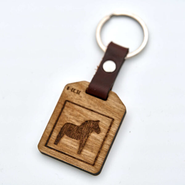 Nyckelring med en Dalahäst. Tillverkad av björkplywood. En bit vegetabiliskt garvat läder binder ihop det hela mot nyckelringen. Tillverkad här i Sverige.