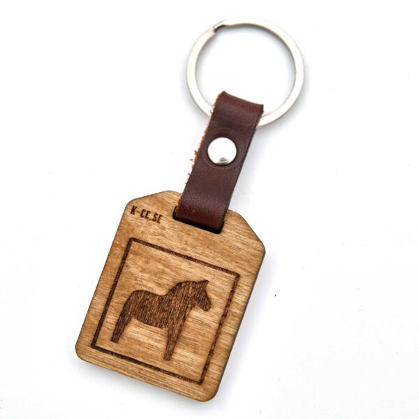 Nyckelring med en Dalahäst. Tillverkad av björkplywood. En bit vegetabiliskt garvat läder binder ihop det hela mot nyckelringen. Tillverkad här i Sverige.