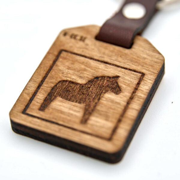Nyckelring med en Dalahäst. Tillverkad av björkplywood. En bit vegetabiliskt garvat läder binder ihop det hela mot nyckelringen. Tillverkad här i Sverige.