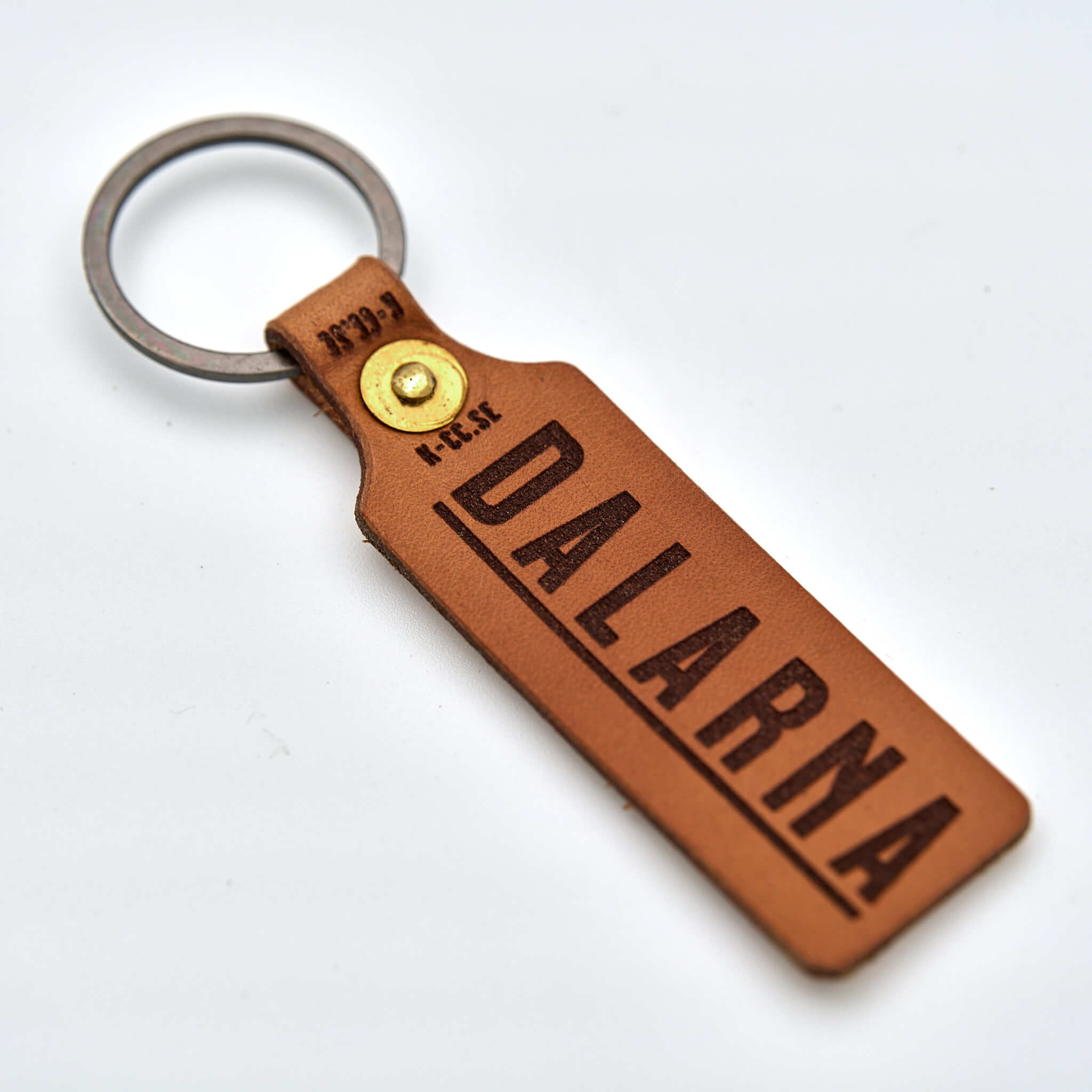 Nyckelring i läder med handpenad mässingsnit prydd med namnet Dalarna graverat. Tillverkad av naturfärgat vegetabiliskt läder här i Sverige.