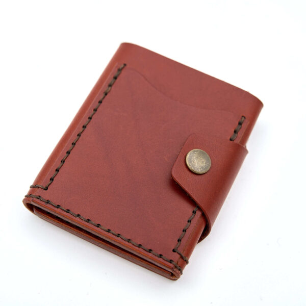 Handsydd tri-fold plånbok med knappstängning i vegetabiliskt garvat läder. Cognacfärgat läder från Tärnsjö Garveri. Tillverkad i Sverige av K Creative Craft.