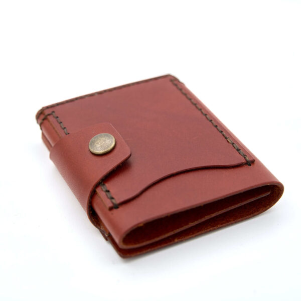 Handsydd tri-fold plånbok med knappstängning i vegetabiliskt garvat läder. Cognacfärgat läder från Tärnsjö Garveri. Tillverkad i Sverige av K Creative Craft.