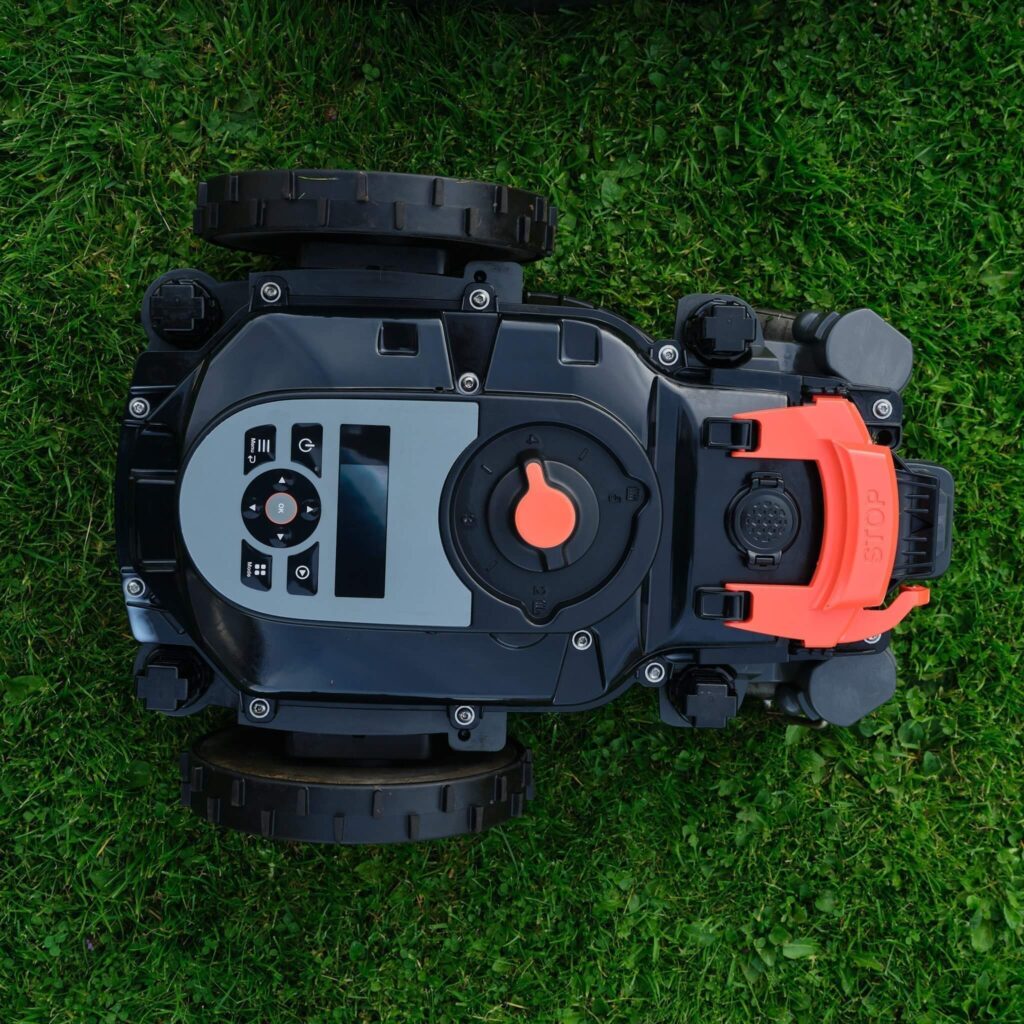 Rengjord Gardena robotgräsklippare under kåpa.