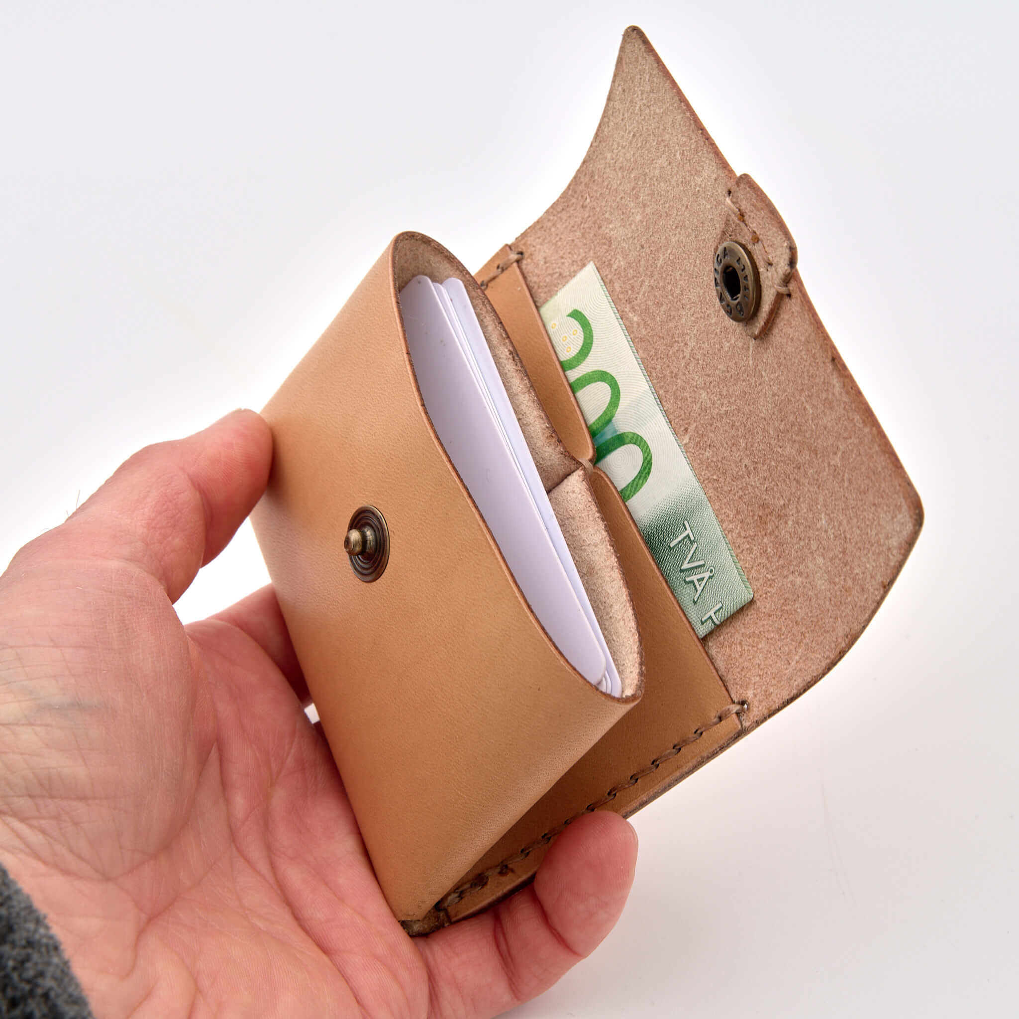 Insida av minibörs i läder med knapp och fack